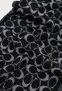 Tecido com padrão preto e cinza, apresentando uma textura de estampa de leopardo cintilante, com pontos elevados e um caimento suave e flexível.