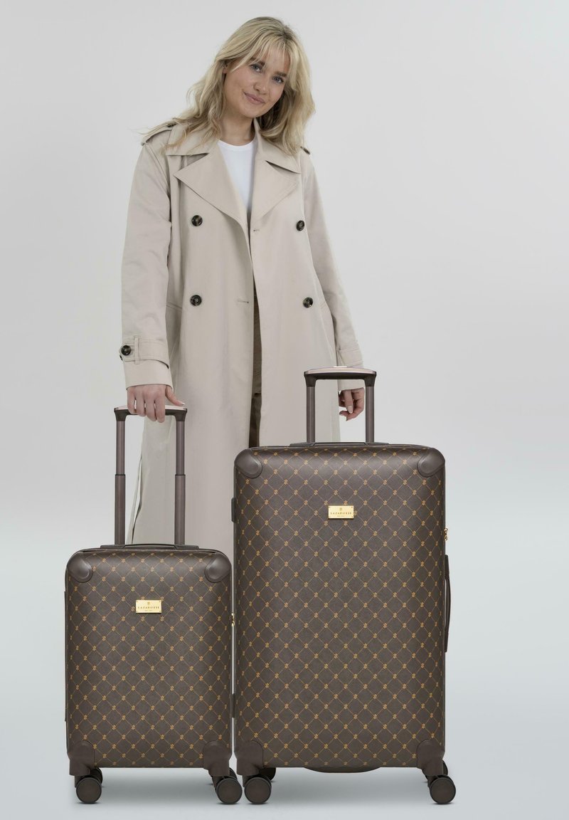 Deux valises brunes à motifs avec des accents dorés, présentant un design en losange, des poignées rétractables et quatre roues pour une mobilité facile.