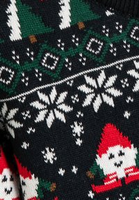 Sweter dziergany z ciemnym tłem, białymi płatkami śniegu, zielonymi drzewami i czerwonymi akcentami, z wesołymi wzorami krasnoludków na całej powierzchni.