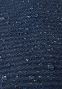 Marine Strukturstoff mit Wassertropfen, der ein wasserdichtes Material zeigt. Die Oberfläche wirkt leicht glänzend mit einem dichten, gewebten Muster.