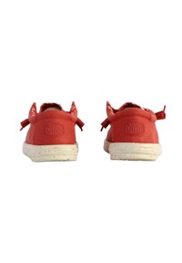 Scarpe rosse in gomma con una superficie testurizzata, dotate di piccoli fiocchi sul retro e una suola bianca maculata. Logo impresso sul tallone.