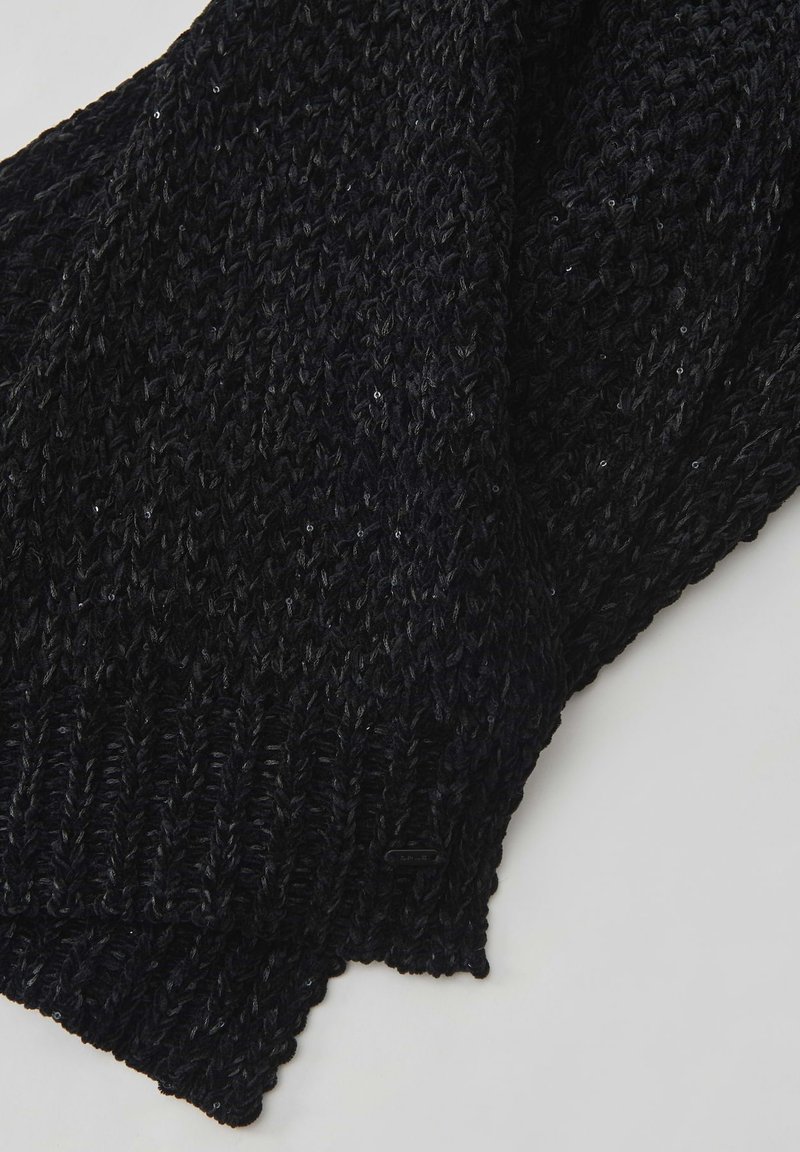 Schwarzer gestrickter Schal mit einem strukturierten Muster und sichtbaren Stichen. Das Material wirkt weich und weist dezente glänzende Akzente auf.