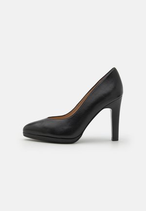 Décolleté nera in pelle con tacco alto, caratterizzata da una punta affusolata, texture liscia e silhouette elegante. Altezza del tacco di circa 10 cm.