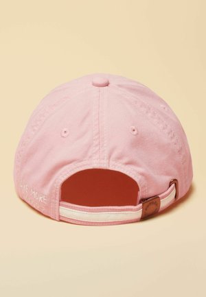 Roze katoenen honkbalpet met verstelbare riem en metalen gesp, lichtbeige achtergrond, kleine geborduurde tekst aan de zijkant bij de opening.