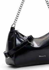 Sac à bandoulière en cuir verni noir avec une sangle chaîne argentée, boucle réglable et petit logo "Tamaris" sur le devant.