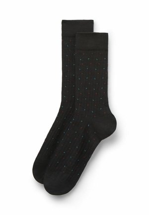 Svarta ribbade strumpor med ett färgglatt prickmönster i röd och blå. Har en längd till mitten av vaden och en slät textur.