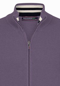 Lilla zip-up sweater lavet af et struktureret strikstof med en ribbekrave. Har stribede detaljer i marineblå og cremefarvet. Mærkets label er synlig.