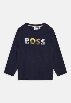 Chemise à manches longues bleu marine en coton, ornée d'un logo "BOSS" multicolore avec des motifs. Comprend des boutons décoratifs sur les épaules.