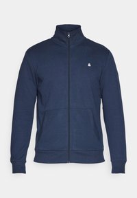 Mornarica zip jakna s patentnim zatvaračem i visokim ovratnikom, dva prednja džepa, rebrasti manžeti i donji rub, izrađena od mekog materijala, s malim bijelim logotipom na prsima.