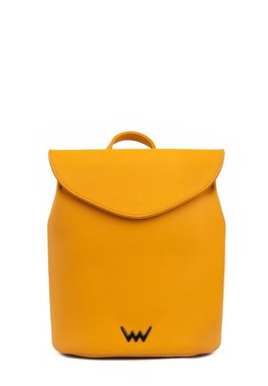 Yellow leather backpack with a rounded flap, top handle, and black logo accent at the bottom. Smooth texture and minimalist design.
