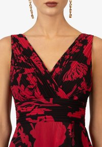 Rotes und schwarzes Blumenkleid mit plissiertem Stoff, tiefem V-Ausschnitt und tailliertem Bund. Verfügt über eine elegante Textur und lebhaften Farbknoten.