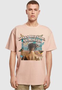 Lyserød bomulds-T-shirt med et grafisk design, der har teksten "DAYS BEFORE SUMMER", sommerfugle og et billede af en figur set bagfra.