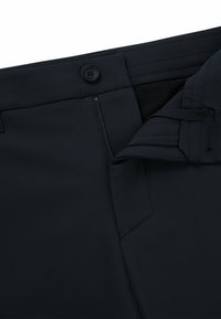 Navy-Hosen mit glatter Textur, ausgestattet mit einem Knopfverschluss und Reißverschluss, entworfen für Komfort mit einem verstellbaren Bund.