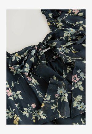 Blumenbluse aus navy Stoff mit hellrosa und gelben Blumen. Sie hat eine Bindeschleife am Ausschnitt und einen elastischen Bund.