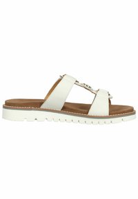 White leather slide sandals with wide straps, flat brown insole, textured white rubber sole, and decorative accent detail on the strap.