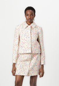 Tweed-Jacke und Rock-Set mit einem mehrfarbigen Design und Pastellakzenten, großen Knöpfen und einem Kragen, das eine strukturierte Optik bietet.
