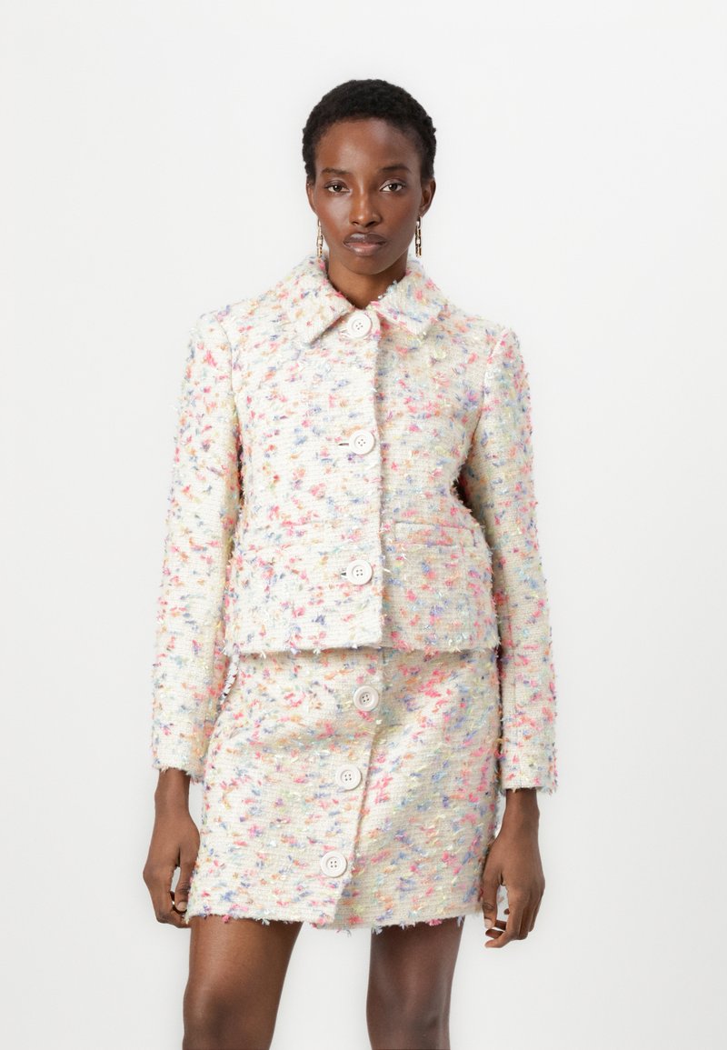 Tweed-Jacke und Rock-Set mit einem mehrfarbigen Design und Pastellakzenten, großen Knöpfen und einem Kragen, das eine strukturierte Optik bietet.