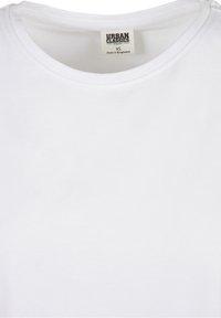 T-shirt blanc en coton biologique avec un col rond, comportant une étiquette "Urban Classics" et une taille XS. Texture lisse, design basique.