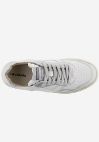Sneaker bianco con tomaia in pelle liscia, punta forata, lacci grigi e suola in gomma crema; presenta un logo sulla linguetta.