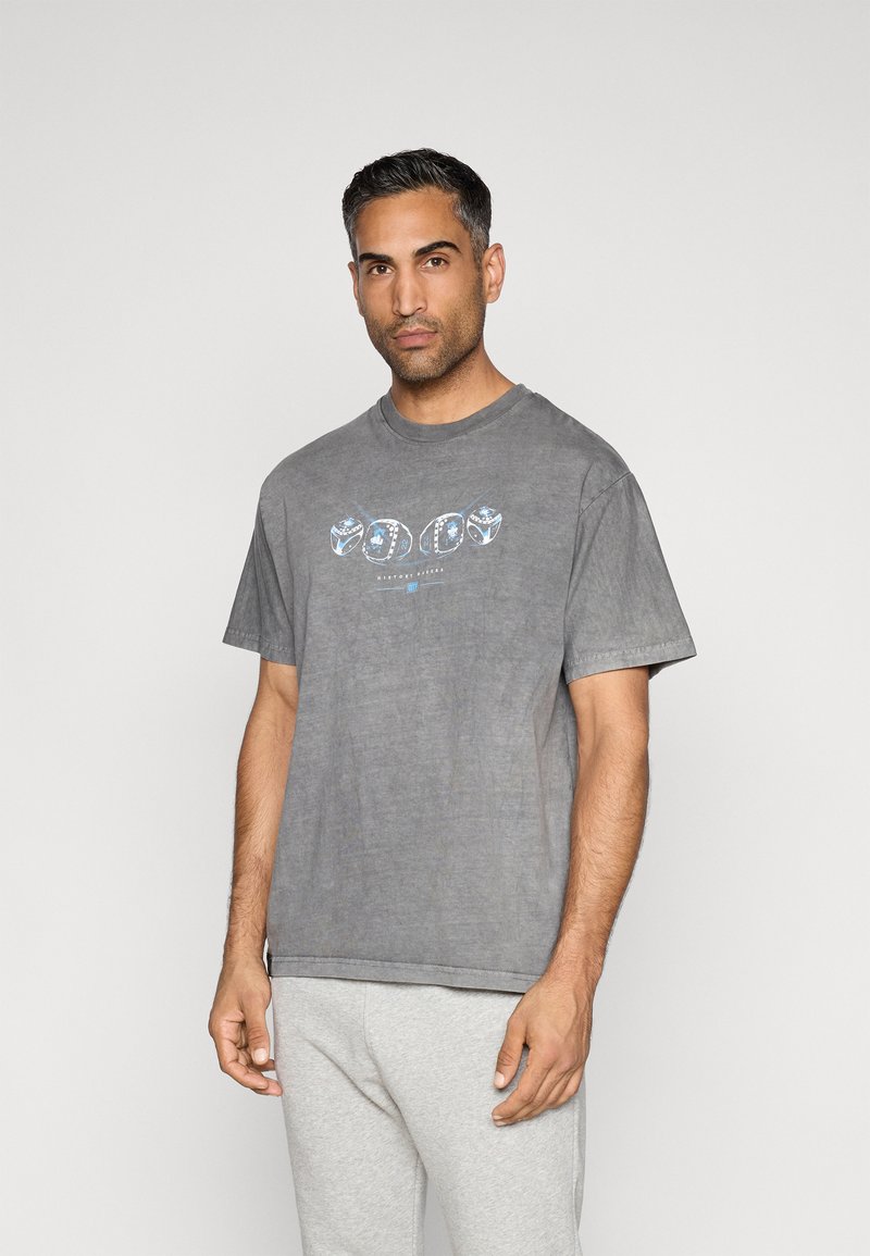 T-shirt cinza de algodão com um corte descontraído, apresentando um design gráfico colorido na frente. Mangas curtas, decote redondo, textura suave.