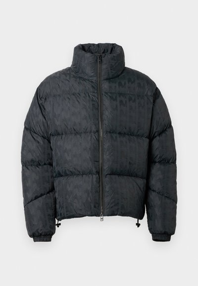 Jachetă puffer neagră cu design matlasat, guler înalt, fermoar frontal și manșete elastice. Textură netedă cu un model subtil.