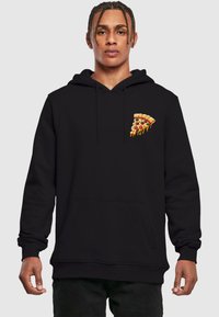 Felpa nera con cappuccio che presenta una grafica di una fetta di pizza con condimenti. Il materiale sembra morbido; include una tasca a marsupio sul davanti e un cappuccio con cordoncino.