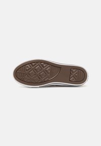 Suela de zapato de goma marrón con un agarre texturizado y con patrón; presenta un borde blanco y un logo en relieve.