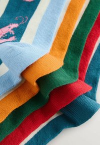 Stapel gefalteter, gestrickter Socken mit vertikalen Streifen in Blau, Orange, Grün, Rot und Creme auf weißem Hintergrund.