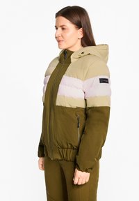 Padded jacket with a hood, featuring olive green, beige, and light pink color blocks. Zippered pockets and elastic cuffs. Soft texture.
