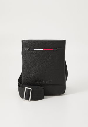 Black leather crossbody bag with textured surface, adjustable strap, and front pocket featuring red, white, and blue accent details.