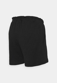Černé šortky vyrobené z texturované látky, s elastickým pasem a bočními kapsami. Design je jednoduchý a ležérní.