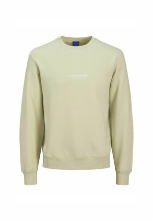 Light green sweatshirt made of soft fabric. Features a crew neckline, long sleeves, and "Originals Studio" printed in white on the front.