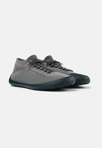 Scarpe sportive grigie con tomaia in mesh traspirante, suola in gomma flessibile e dettagli testurizzati. Presentano lacci e un design low-cut.