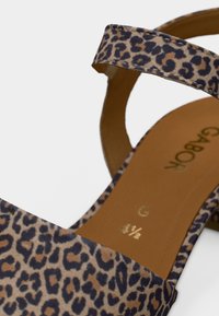 Σανδάλι με λεοπάρ μοτίβο, υφασμάτινο επάνω μέρος με υφή, ανοιχτή σχεδίαση δαχτύλων και επίπεδο τακούνι. Διαθέτει ένα μόνο λουράκι μπροστά.