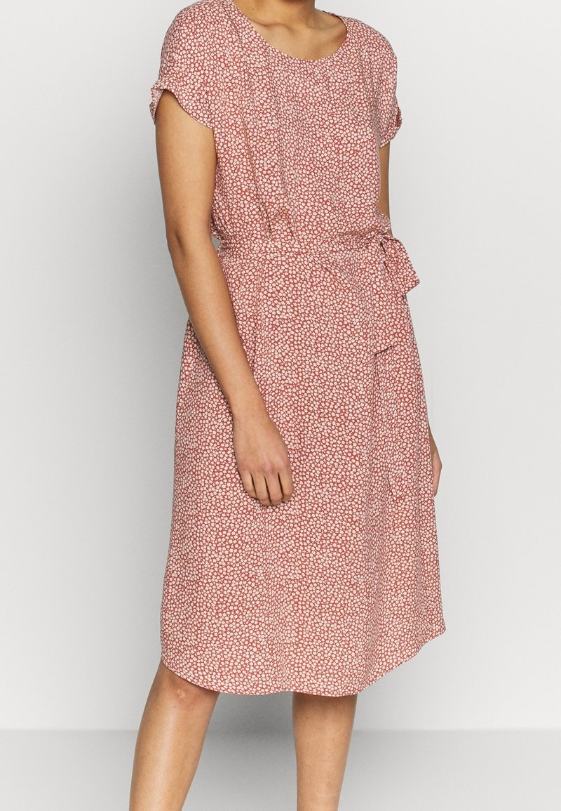 Robe à imprimé floral rouge avec des manches courtes, un col rond et une ceinture à la taille, fabriquée à partir d'un tissu léger avec une silhouette fluide.