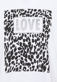 Weißes T-Shirt mit einem Schwarz-Weiß-Leopardenprint-Design. Ein rechteckiges Panel aus silbernem Glitzer zeigt das Wort "LIEBE" in fetten Buchstaben.