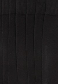 Calzini neri con una texture liscia e un design a maniche rigate. Sei paia disposti in fila, mostrando lunghezza e colore uniformi.