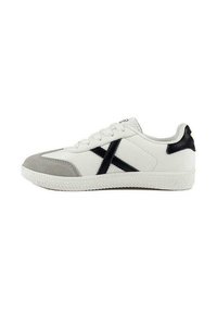 Sneaker bianco in pelle con dettagli neri, punta in suede grigio, suola in gomma testurizzata e un distintivo design a X nera sul lato.