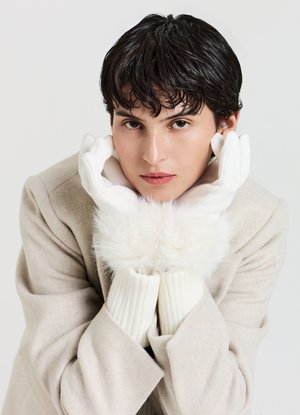 Gants blancs avec une bordure de fourrure douce aux poignets, assortis à un manteau beige clair. Les gants présentent une texture lisse et une coupe ajustée.