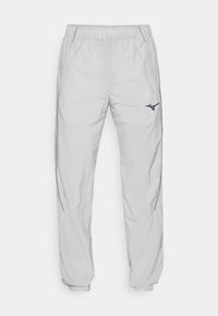 Lichtgrijze joggingsbroek van glad, synthetisch materiaal; beschikt over een elastische tailleband, zijzakken en een klein zwart logo.