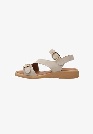 Béžová semišová sandal s dvěma nastavovacími pásky s zlatými přezkami a nízkou opálenou klínovou podrážkou.