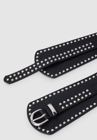 Cinturino in pelle nera con borchie d'argento. Presenta una fibbia e una superficie testurizzata. Le sezioni del cinturino sono allungate con accenti borchiati lungo i bordi.