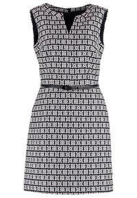 Robe sans manches noire et blanche à motifs, avec un encolure en V fendue et une fine ceinture noire à la taille.