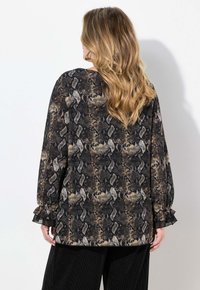 Blusa nera con stampa in pelle di serpente, maniche lunghe e polsini arricciati, realizzata in tessuto leggero. Presenta un design ampio e fluido.