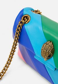 Borsa in pelle color block nelle tonalità blu, verde, viola e rosa, con tracolla in catena dorata e dettaglio decorativo a forma di gufo dorato sulla chiusura.