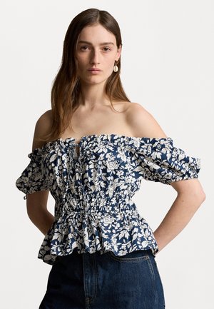 Blusa de hombros al aire en azul marino con un patrón floral blanco. Presenta mangas y cinturilla fruncidas para una forma de peplum con volantes. Tejido suave.