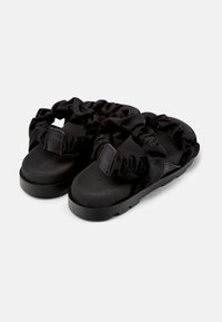 Svarta sandaler med rynkade tygremmar och en strukturerad fotbädd, samt en platt och stabil gummisula som ger stabilitet och komfort.