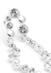 Pendientes de plata que presentan cristales redondos de diferentes tamaños, con una textura suave y brillante y un diseño enlazado que muestra gemas transparentes.