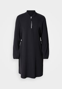Robe noire manches longues avec col montant et fermeture éclair partielle à l'avant avec tirette étiquetée "SPORTS."