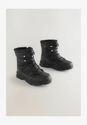 Črne zimske čevlje z zgornjim delom iz teksturirane tkanine, podlogo iz umetnega krzna, elastičnimi trakovi in stranskim zadrgo. Rugged gumijast podplat za oprijem.